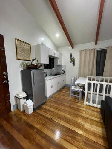 a kitchen and living room with a refrigerator and a table at Rest Terraces Transient House in Baguio