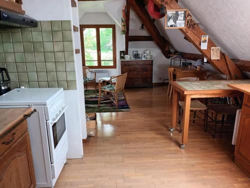 a kitchen with a table and a dining room at La Chaumière, Formule maison entière in Colmars