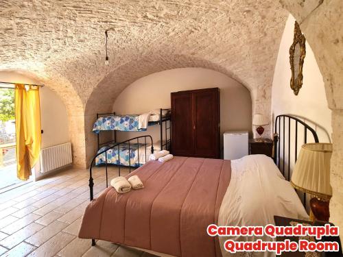 a bedroom with a bed in a stone room at Masseria Puglia Antica in Monopoli