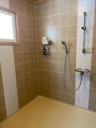 a bathroom with a shower with a window and a tub at Karhurinne Koli in Hattusaari