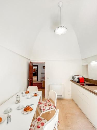 a kitchen and dining room with a white table and chairs at I Trulli e la Luna in Alberobello