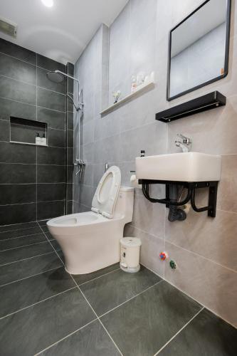 a bathroom with a sink and a toilet and a mirror at Mai An Home in Da Lat