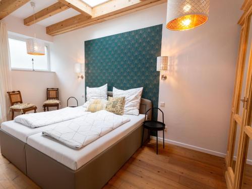 a bedroom with a large bed with a green accent wall at Ejas Haus am Meer in Lubmin