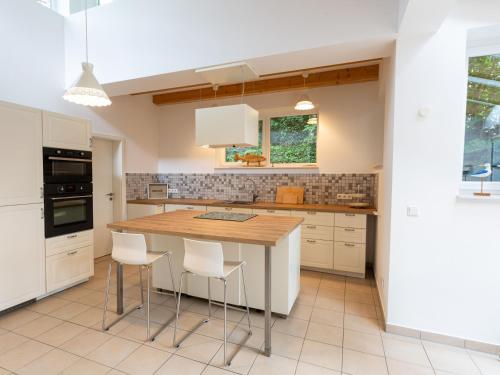 a kitchen with a wooden table and white cabinets at Ejas Haus am Meer in Lubmin