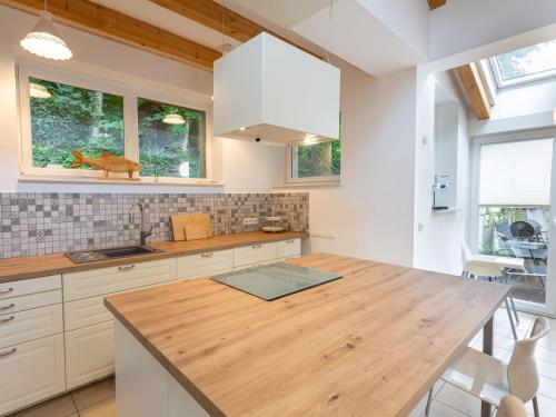 a kitchen with white cabinets and a wooden counter top at Ejas Haus am Meer in Lubmin