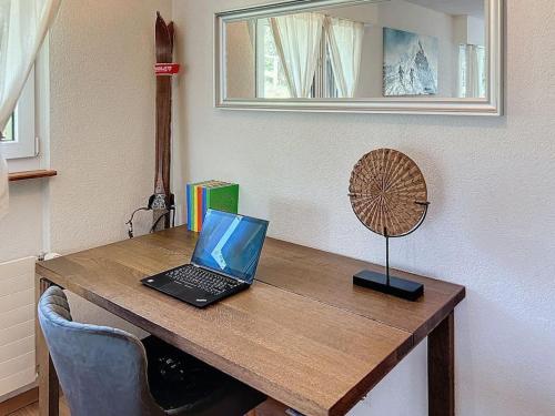 a laptop computer sitting on top of a wooden desk at Christiania Central Nendaz in Nendaz