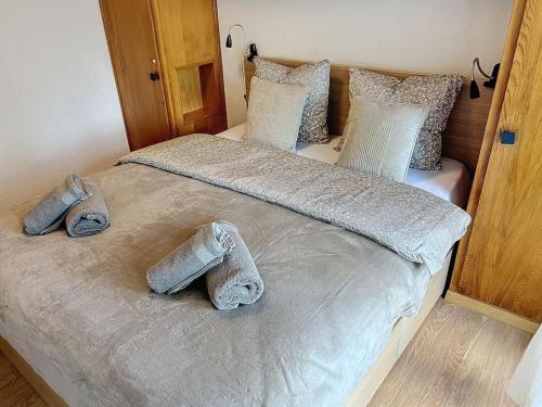 a bed with two pairs of shoes on it at Christiania Central Nendaz in Nendaz