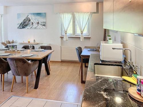 a kitchen and dining room with a table and chairs at Christiania Central Nendaz in Nendaz