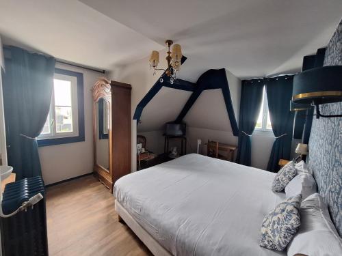 a bedroom with blue curtains and a white bed at Hotel de Charme La Bonne Adresse - Logis hotels in Le Havre
