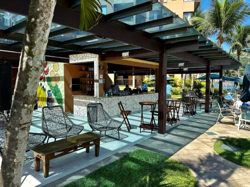 a patio with chairs and tables and a bar at Piscina, Mar e estilo em Angra dos Reis in Angra dos Reis