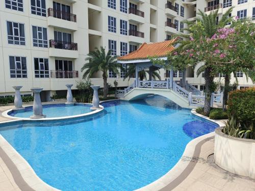 a large swimming pool in front of a building at 2BR Lucky Tower Residence Jakarta Old Town Top Floor Condo in Jakarta