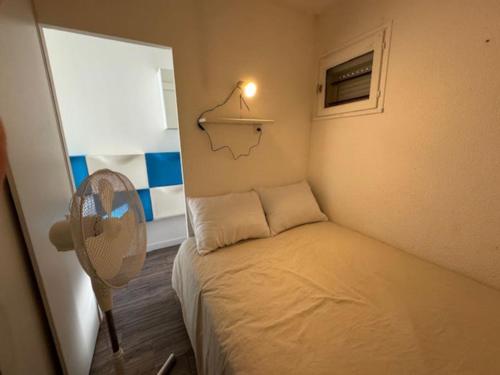 - une petite chambre avec un lit et un ventilateur dans l'établissement Appart Cap d'Agde de 1 à 4 personnes, A 2 min du port à pied, au Cap d'Agde