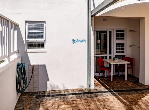 a white building with a table and a window at Withuis Hartenbos - No Load Shedding in Hartenbos