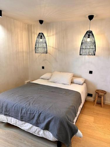 - une chambre avec un lit et deux lampes pendant dans l'établissement Villa de charme avec grand jardin centre Trouville sur mer, à Trouville-sur-Mer