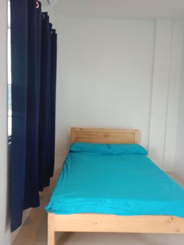 a bed with a wooden frame and blue sheets at The Soul Center in Batuan