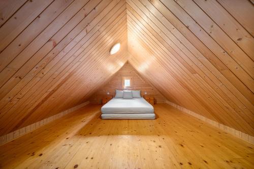 a bed in a room with a wooden ceiling at Chalupa U Horníků in Vítkovice