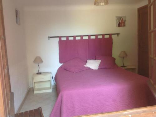 - une chambre avec un lit et une couverture violette dans l'établissement Les lauriers roses, à La Croix-Valmer