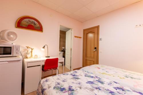 a bedroom with a bed and a desk and a microwave at Mirador 2 del Mercado Central - habitacion con baño privado en el centro de la Ciudad Vella in Valencia