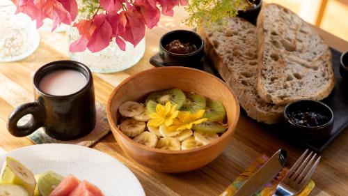una mesa con un bol de fruta y un plato de pan en Dejama Glamping Resort Lombok, en Bumbang