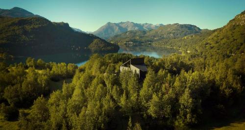 a house on a hill in the middle of a lake at MA PU LODGE Futaleufu in Futaleufú