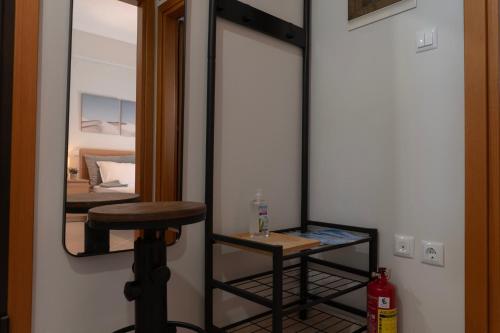 a mirror in a room with a stool and a table at Serene Suites, STR Hospitality MNGMT in Kilkís