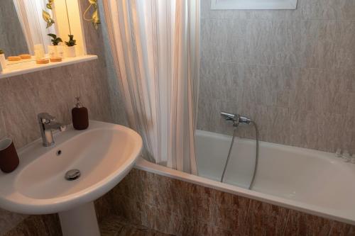 a bathroom with a sink and a shower and a tub at Serene Suites, STR Hospitality MNGMT in Kilkís