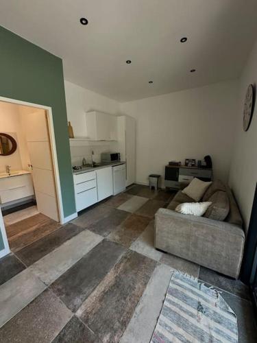 un salon avec un canapé et une cuisine dans l'établissement studio sur jardin et piscine, aux Pennes-Mirabeau