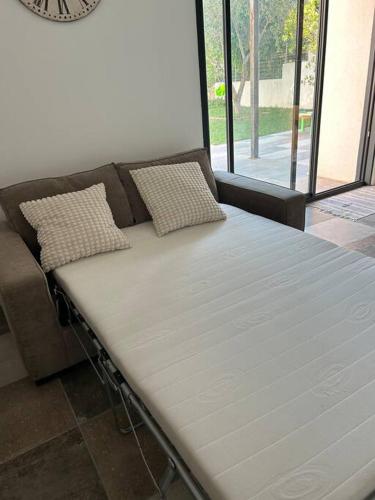 - un lit installé à côté d'un canapé dans l'établissement studio sur jardin et piscine, aux Pennes-Mirabeau