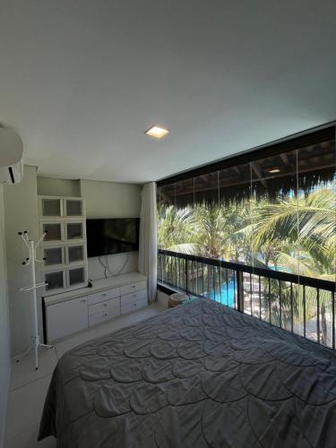 a bedroom with a large bed and a large window at Cobertura Parque das Ilhas in Mangabeira