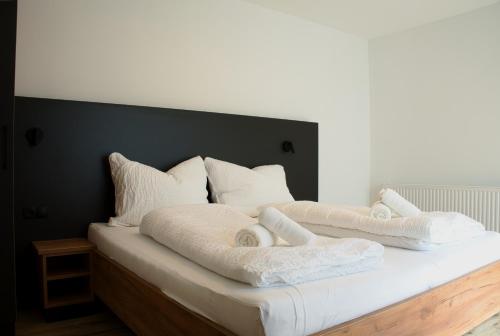 a bed with white blankets and pillows on it at myQuartier City Chalets in Innsbruck