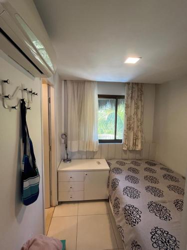 a small bedroom with a bed and a window at Cobertura Parque das Ilhas in Mangabeira