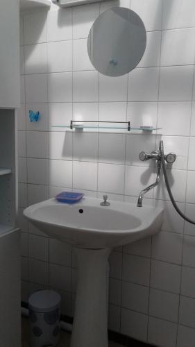 une salle de bain avec un lavabo blanc et un miroir dans l'établissement villa Les Pieds Dans l'Eau sur les plages du débarquement, à Saint-Germain-de-Varreville