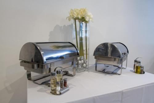 a table topped with a grill and a vase of flowers at Guest House Frizzante in Turčianske Teplice