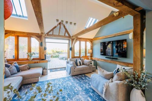 a living room with couches and a flat screen tv at Super Host Large Luxury Cottage South Downs Park in Lodsworth