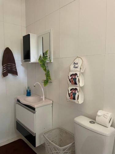 a bathroom with a sink and a toilet and a mirror at Casa Mobiliada próximo do restaurante Bosque da Serra in Santa Fé