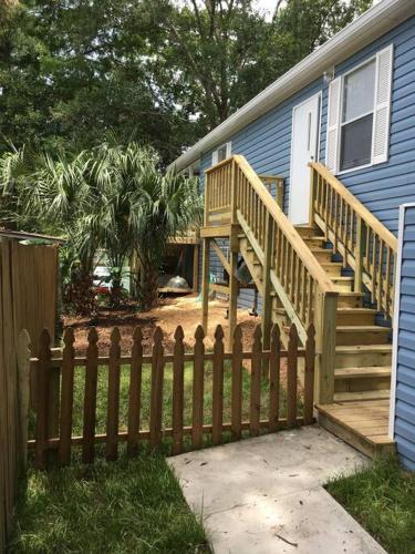 a wooden fence in front of a house at The Chuby Mermaid - Weeki Wachee River Access Waterfront with Paddlecraft in Spring Hill