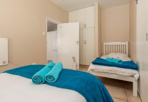 a bedroom with two beds with blue towels on it at Withuis Hartenbos - No Load Shedding in Hartenbos