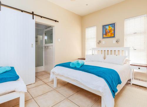 a bedroom with a white bed and a shower at Withuis Hartenbos - No Load Shedding in Hartenbos