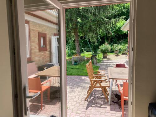 an open door to a patio with a table and chairs at Baglyos Vendégház Kulcs in Kulcs