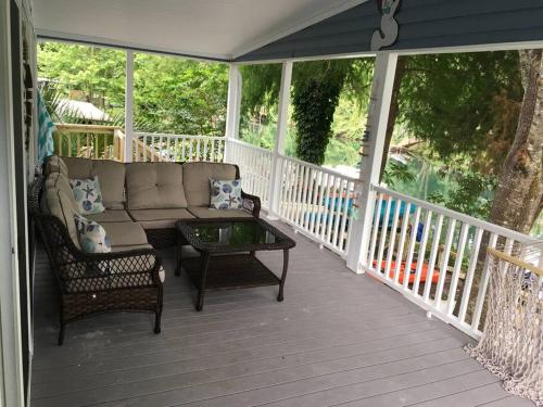 a screened in porch with a couch and a coffee table at The Chuby Mermaid - Weeki Wachee River Access Waterfront with Paddlecraft in Spring Hill
