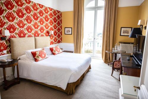 a bedroom with a bed and a desk and a television at Domaine de la Tortinière in Montbazon