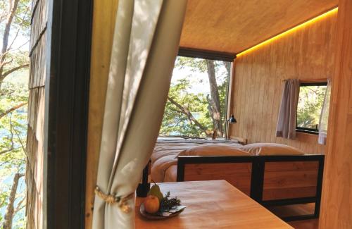 a room with two beds and a table and a window at MA PU LODGE Futaleufu in Futaleufú