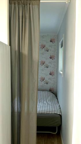a small bed in a small room with a curtain at Green Forest Oasis & Sea in Strömstad