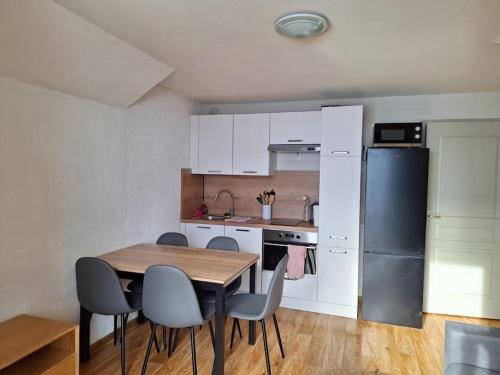 une cuisine avec une table, des chaises et un réfrigérateur dans l'établissement Albiez Montrond T2 34m2, 6 personnes, à Albiez-Montrond