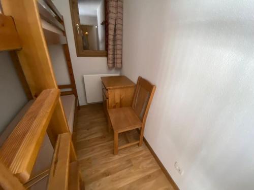 une chaise en bois dans une chambre avec un miroir dans l'établissement Albiez Montrond T2 34m2, 6 personnes, à Albiez-Montrond