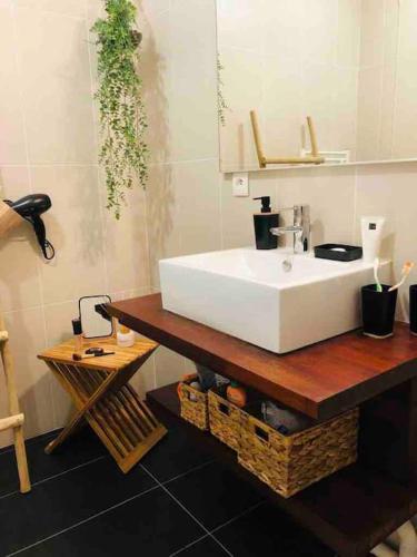 La salle de bains est pourvue d'un lavabo blanc sur une table en bois. dans l'établissement T3 duplex Port de La Teste Bassin d Arcachon, à La Teste-de-Buch