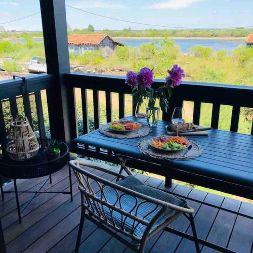 une table bleue avec des assiettes de nourriture et des fleurs sur un balcon dans l'établissement T3 duplex Port de La Teste Bassin d Arcachon, à La Teste-de-Buch
