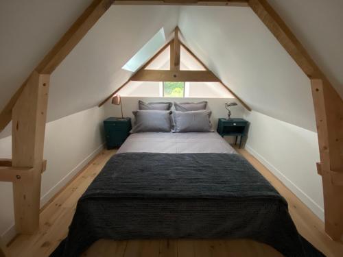 une chambre avec un lit dans un grenier dans l'établissement Le repaire de Zo entre St Malo, Dinan et Dinard, à Langrolay