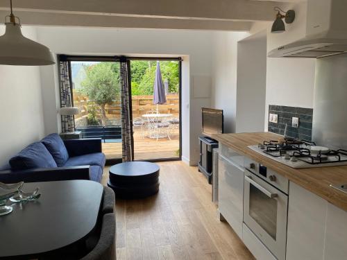 une cuisine et un salon avec un canapé et une table dans l'établissement Le repaire de Zo entre St Malo, Dinan et Dinard, à Langrolay