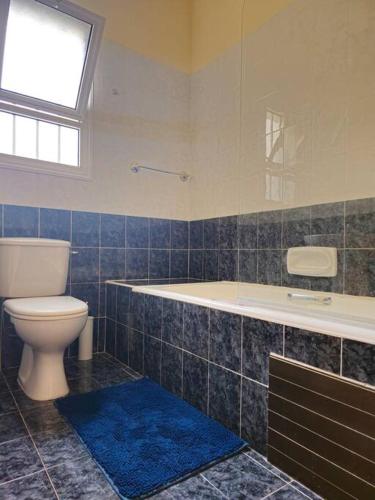 a bathroom with a toilet and a tub and a window at Villa & pool 3 bedrooms 2 minutes from the beach in Maa
